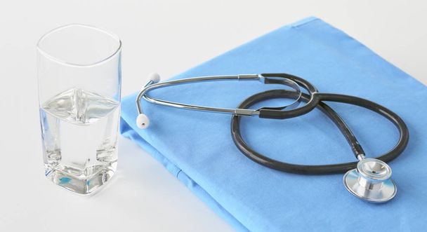 Stetoskop na stůl s lékařskou uniforma - Fotografie, Obrázek