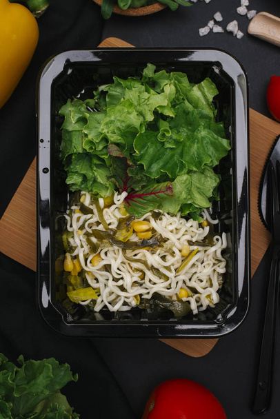 Здоровое вегетарианское блюдо из капусты, водорослей и свеклы в черном лотке
 - Фото, изображение