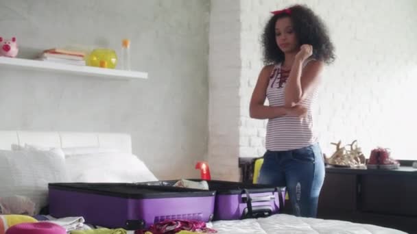 Linda chica afroamericana bolsa de embalaje para vacaciones y viajes
 - Imágenes, Vídeo