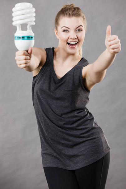 Happy woman holding eco modern light bulb. Innovation technology, power saving concept. - Fotografie, Obrázek
