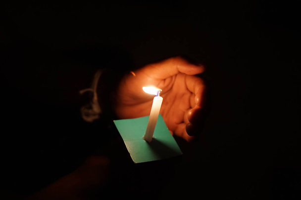 Llama de la vela en la noche con bokeh sobre fondo oscuro con ir luz Bendita es la luz de la santidad y los milagros
. - Foto, imagen