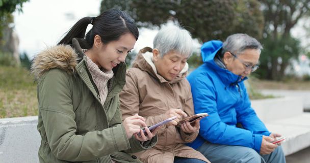 Asian Family using smartphones in the street  - Photo, Image