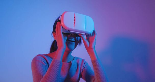 Mulher olhando com realidade virtual com luz vermelha e azul
  - Foto, Imagem