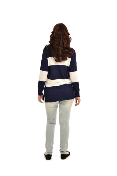 Ganzkörperporträt eines Mädchens in Jeans und lässigem Pullover. Stehende Pose, isoliert auf weißem Studiohintergrund. - Foto, Bild