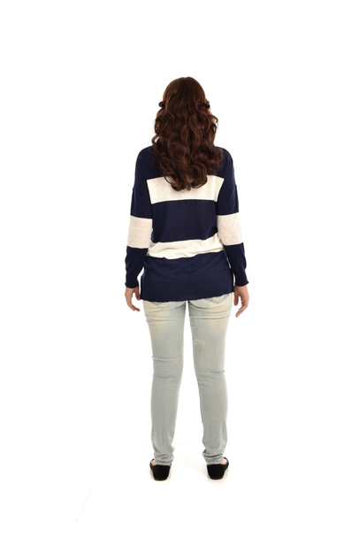 po celé délce portrét dívka, která nosí džíny a ležérní svetr. představovat stojící, izolované na bílém studio pozadí. - Fotografie, Obrázek