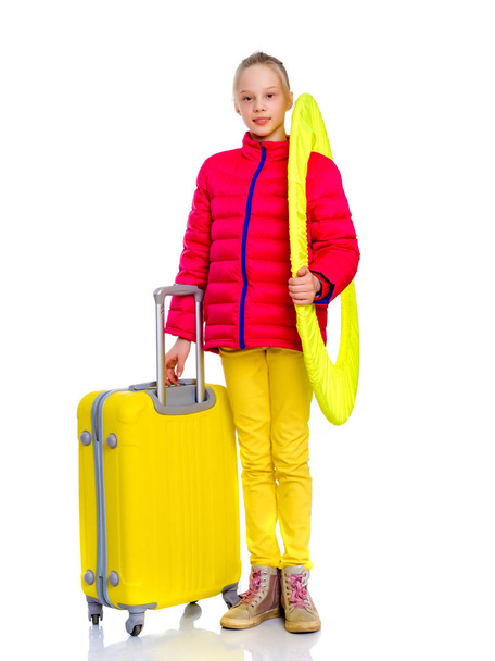 The girl gymnast with a large suitcase goes to the competition. - Foto, imagen