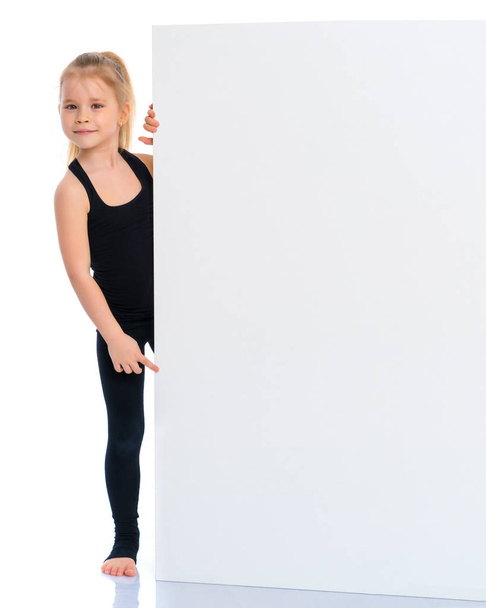 Little girl points a finger at a white banner. - Zdjęcie, obraz