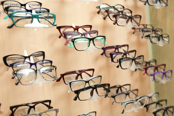Showcase with different glasses in optical store. Ophthalmologist prescription - Photo, Image