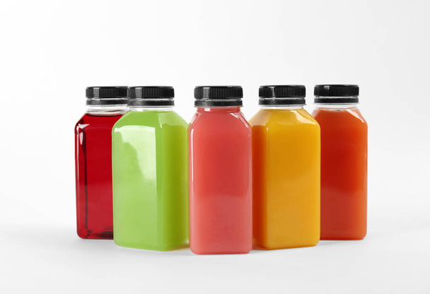 Bottles with delicious colorful juices on white background - Foto, afbeelding
