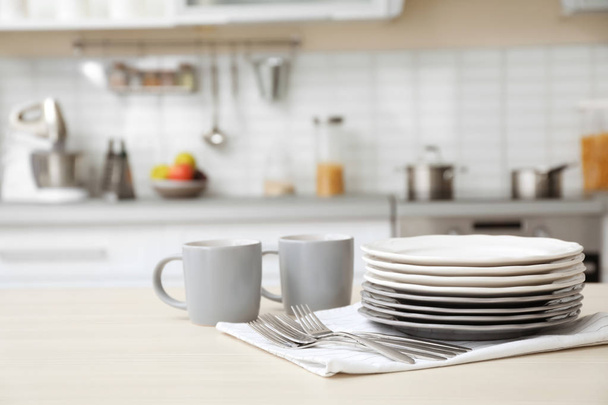 Tableware and blurred view of kitchen interior on background - Фото, изображение