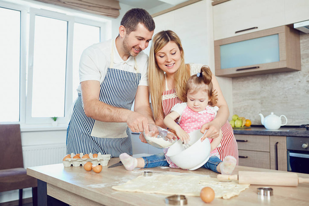 A happy family prepares baking in the kitchen - Photo, image