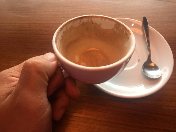 Male hands holding cups of coffee on wooden table background,No coffee - Φωτογραφία, εικόνα