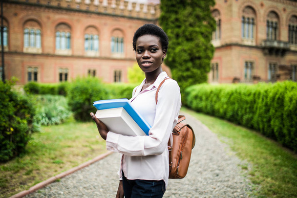 attractive african university student on campus with books - Фото, изображение