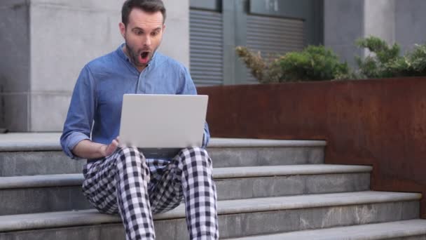 Shocked, Stunned Casual man Using Laptop while Sitting on Stairs Outside Office - Video