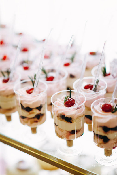 Closeup of festive desserts with berries in cups with spoons - Zdjęcie, obraz