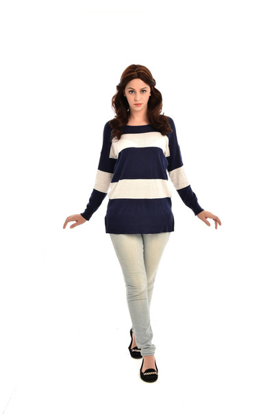 full length portrait of girl wearing striped blue and white jumper and jeans. standing pose on white studio background. - Фото, зображення