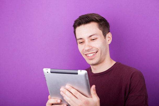 Smiling man holds a digital tablet PC in his hands - Fotó, kép