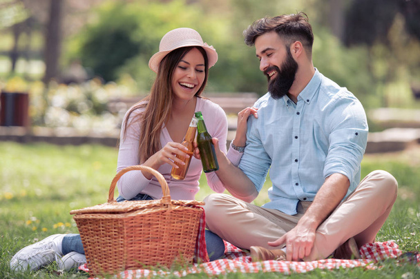 公園でピクニックを持っているカップルを愛する若い. - 写真・画像