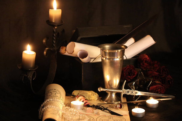 Mustan magian loitsuja. Wicca-loitsuja ja yrttejä. Still Live: Vanhat öljylamput, antiikkikirjat, kuivatut ruusunuput, palava kynttilä kuparikulhossa, lääkepullot, laventeli, Pulsatilla pratensis antiikkipohjalla. Wicca-tausta
. - Valokuva, kuva