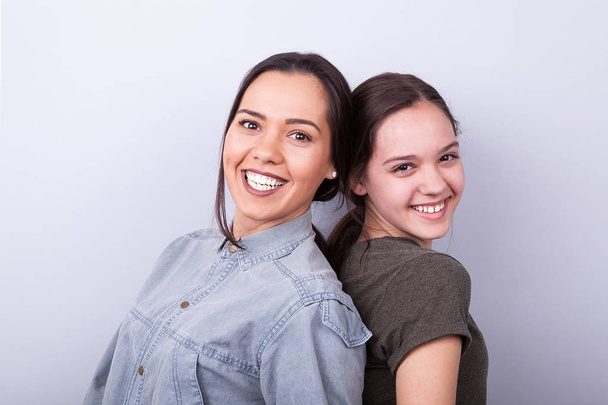 Δύο αδελφές ευτυχισμένη σε γκρίζο φόντο - Φωτογραφία, εικόνα