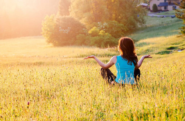 Fiatal, boldog nő hegyekben napkeltekor emelt karokkal. Szabadság és pihenjen koncepció - Fotó, kép