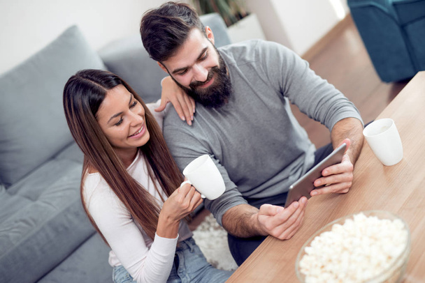 romantisches Paar mit Tablet-Computer. Junges Paar zu Hause surft zusammen. - Foto, Bild
