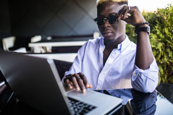 Portret laptopa pracy młodych afro amerykański biznesmen w café teracce - Zdjęcie, obraz