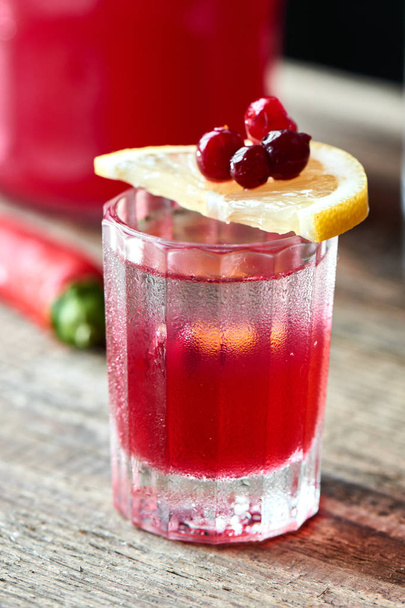 Boyarsky alcoholic cocktail consisting of vodka and homemade cranberry with Tabasco in glass on wooden table, close-up - Foto, imagen
