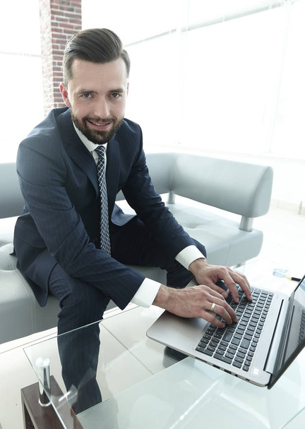Smiling businessman browsing information on laptop, - Foto, Bild