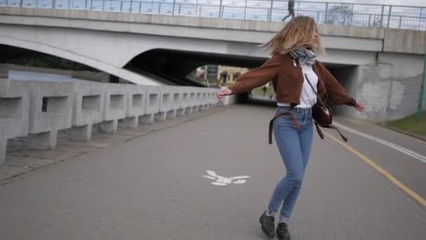 Ευτυχισμένος κορίτσι γυρίζει στο φόντο της πόλης - Πλάνα, βίντεο
