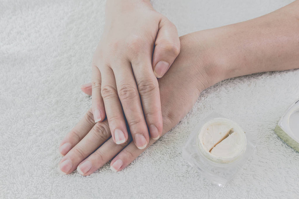 Женские руки с банкой крема на тканевом фоне
 - Фото, изображение