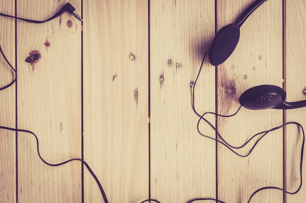 Headphones on wooden table with copy space - 写真・画像
