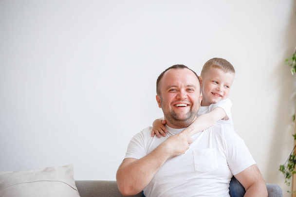 Photo of young father with his son on empty background - Foto, afbeelding