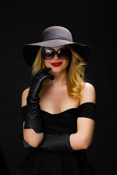 Foto van jonge blonde in hoed, bril en handschoenen - Foto, afbeelding