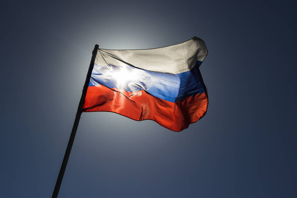 rosyjski banderą, w zwolnionym tempie i z powrotem, oświetlone przez słońce. - Zdjęcie, obraz