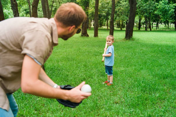 father and son playing baseball at park - Fotó, kép