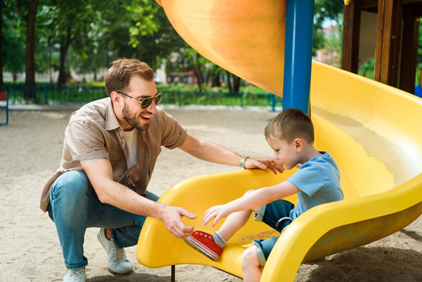 feliz padre e hijo se divierten en el parque infantil en el parque
 - Foto, Imagen