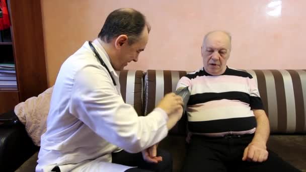 Family doctor measures patients blood pressure. - Felvétel, videó