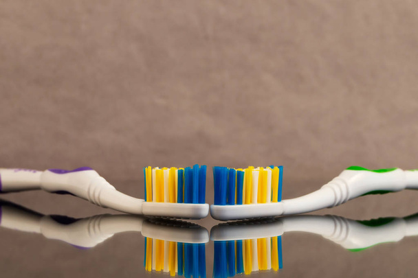 Deux brosses à dents avec une soie de fibres artificielles de différentes couleurs avec réflexion dans le verre
. - Photo, image