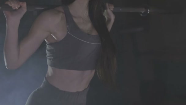 Повнометражний образ молодої жінки, яка випробовує свою силу, тримаючи на плечах штангу з важкими вагами
 - Кадри, відео
