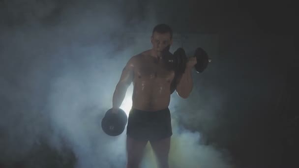 Sterke sportman tillen van zware halters in rook - Video