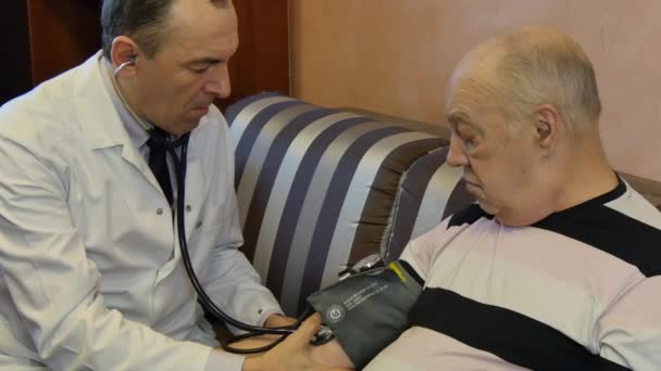 Family doctor measures patients blood pressure. - Materiał filmowy, wideo
