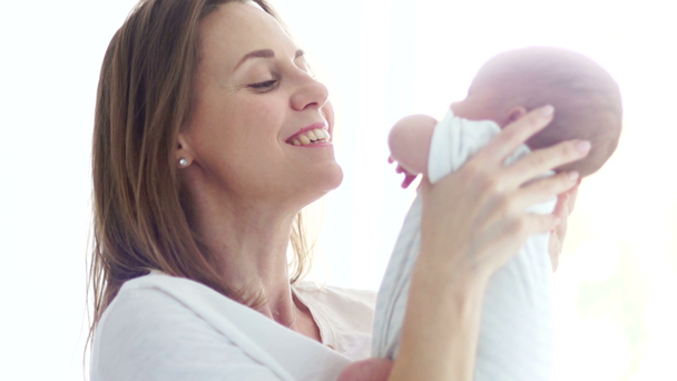 Una madre feliz sostiene a un bebé de dos semanas en sus brazos. Feliz maternidad. Día de las Madres
 - Imágenes, Vídeo
