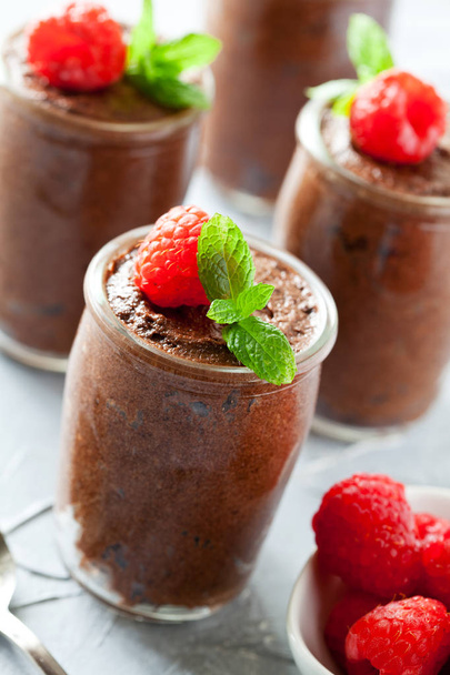 Glass of homemade dark chocolate mousse with raspberries - Photo, Image
