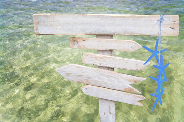 Rustykalne biały puste znaki drewna z niebieski rozgwiazda nad świeży zielony ocean woda o Es Trenc, Mallorca - Zdjęcie, obraz