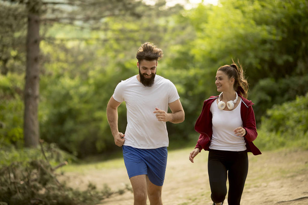 Young couple jogging outdoors in nature - Photo, Image