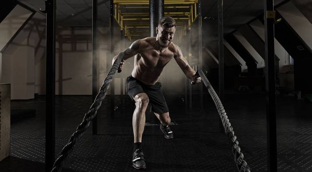 Man working out with battle ropes at gym - Φωτογραφία, εικόνα