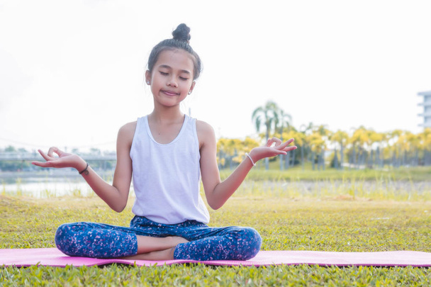 lány boldog, és Meditálj a gyakorlatban jóga a parkban - Fotó, kép