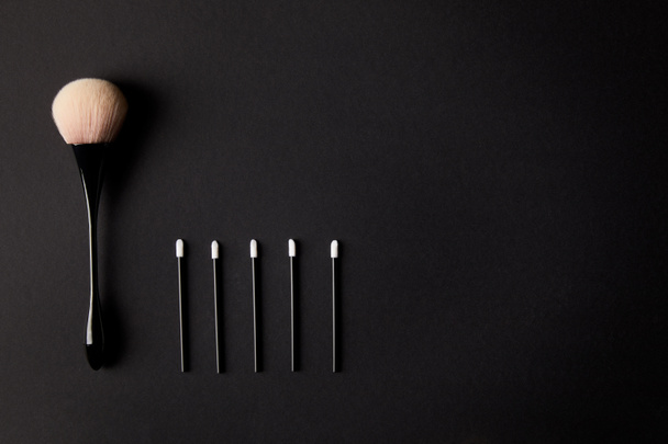 top view of one big and five small makeup brushes on black background - Photo, Image