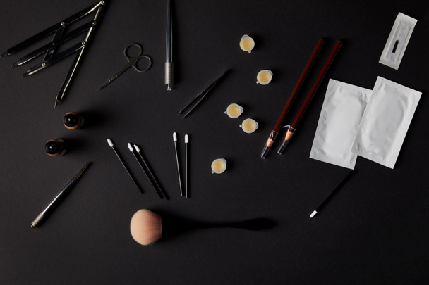 ylhäältä näkymä harjat, kynät, kosmetiikka ja työkalut pysyvää meikkiä musta
 - Valokuva, kuva